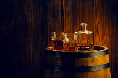 alcoholic beverages in glasses with a glass carafe on the barrelの写真素材