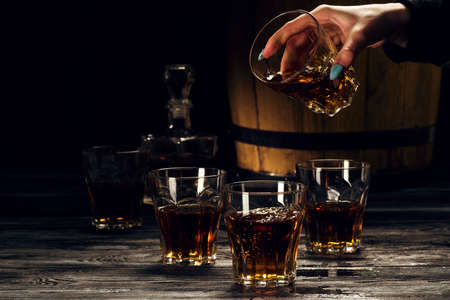 brandy and brandy in decanters stand on an oak barrel, strong alcoholic drinks in the basementの写真素材