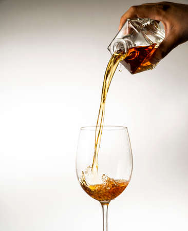 wine is poured into a glass on a light background
