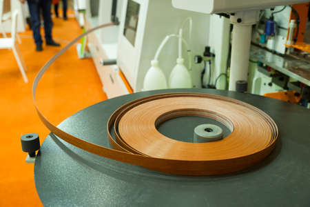 veneered furniture edge in a roll on the machine