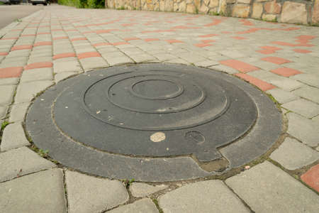 installed sewer hatch on the sidewalk, metal sewer hatch