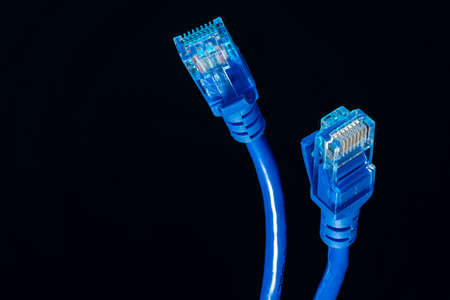 blue Ethernet wire, 8 pin connector for Internet information networks isolated on black backgroundの写真素材