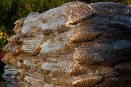 tree bark and woodchips for landscaping in bags for sale on pallets in a garden centertree bark and wood chips for designersの写真素材