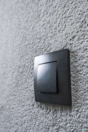 Black switch on a dark gray wallの写真素材