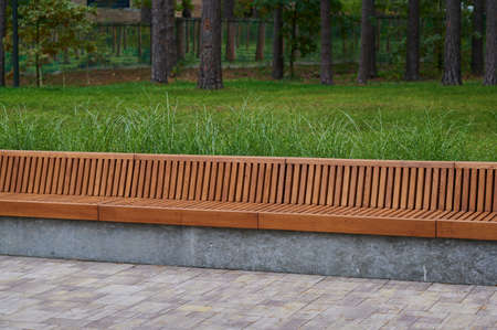 rest seat made of wood on concrete and marble in an urban landscape park environment