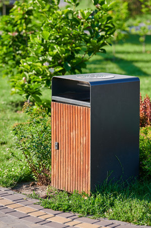 waste basket and cigarette butts in the park landscaping on a green lawn on a sunny dayの写真素材