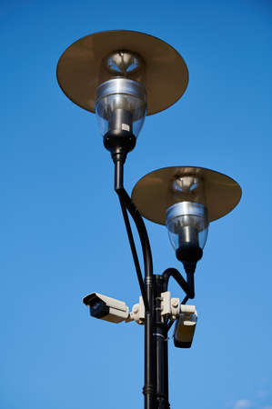 street lamppost with installed video surveillance cameras in the city against the blue sky, sunny weather in the daytime CCTVの写真素材
