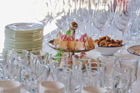 meringue cakes on a two-tiered tray with dishes on a table at a party for receiving guests at an event in a restaurantの写真素材