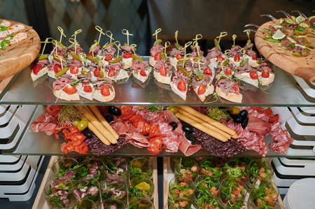 Assortment of cold cuts and snacks on the event on the showcase of the cateringの写真素材