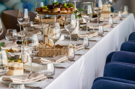 served table in a restaurant for receiving guests, serving dishes for visitors at a holiday at a large tableの写真素材