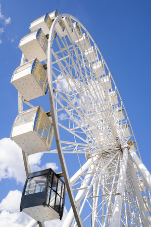 White large Ferris wheel for tourists, against the background of a blue skyの写真素材