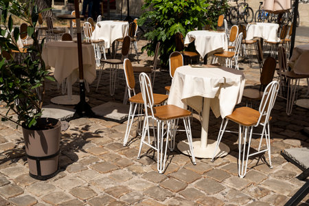 tables with a tablecloth and chairs on a summer terrace in a cafe, outdoor furniture for restaurants on a sunny dayの写真素材