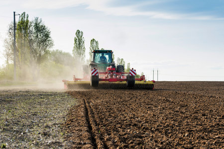 tractor during sowing in an open field on a sunny dayの写真素材
