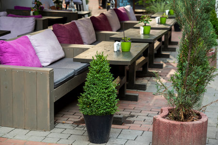 tables and chairs on the terrace in a cafe, outdoor furniture for restaurants, of design and decoration of architecture, shot close-upの写真素材