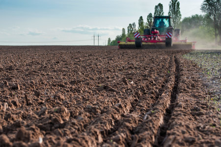 tractor in the field during the sowing season on a sunny day, in a free field in agricultureの写真素材