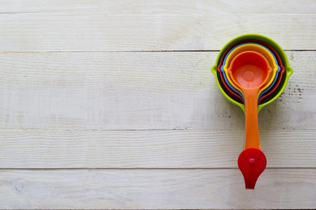Colorful measuring spoons for kitchen on a white wooden backgroundの写真素材