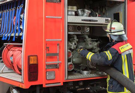 Firefighter uses a water hose to the Emergency Vehicle