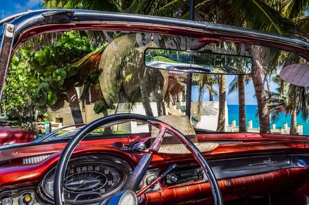 HDR - Interior view from a american red cabriolet vintage car on the beachの写真素材