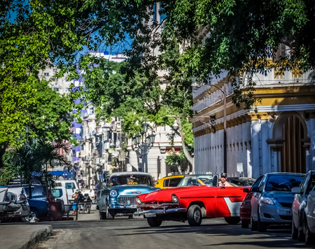 Street scenery in Havana City Cuba with an American red convertible classic car