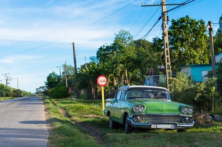 American green classic parked car on the side strip in Cienfuegos Cuba - Series Cuba Reportageの写真素材