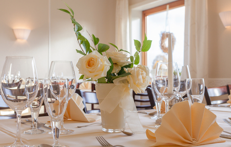 Festive table arrangement with glasses and served and flowersの写真素材