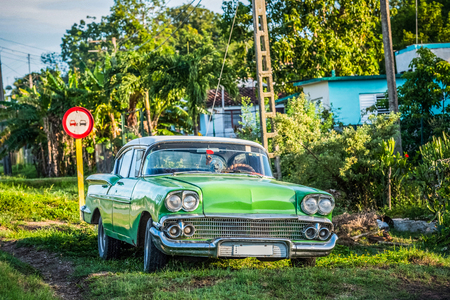 American green classic parked car on the side strip in Cienfuegos Cuba - Series Cuba Reportageの写真素材