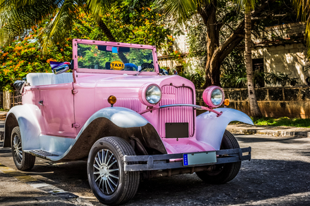 American rose convertible classic car parked under palms in Varadero Cuba - Series Cuba Reportageのeditorial素材