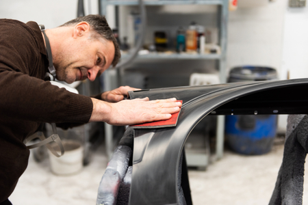 Car mechanic grinds a car part in handicraft in a service station - Serie car repair workshopの写真素材