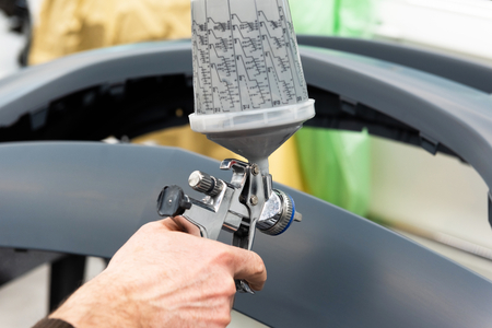 Professional car varnisher at work in a service station - Serie car repair workshopの写真素材