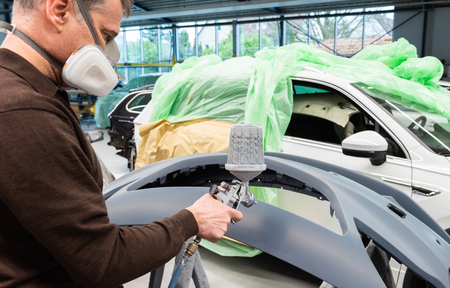 Professional car varnisher at work in a service station - Serie car repair workshopの写真素材