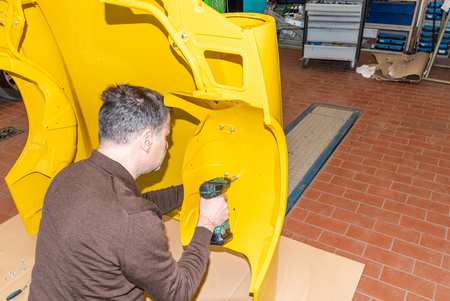 Car mechanic screws car parts together again after restoration - Serie Repair Workshopの写真素材