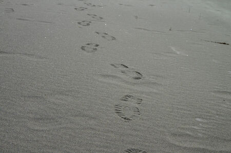 Background with footprints on a sandy beach