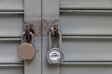 NEW YORK CITY, USA - AUGUST 23, 2015: Two padlocks on the closed iron shuttersのeditorial素材