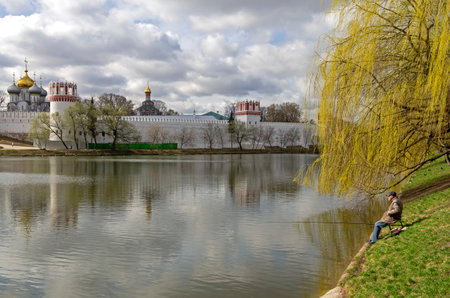 MOSCOW, RUSSIA - APRIL 21, 2016: Lone fisherman on the pond at the Novodevichy Monastery, Moscow. Mid-April.のeditorial素材