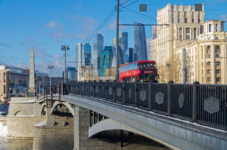 MOSCOW, RUSSIA - JANUARY 21, 2017: Red double-decker sightseeing bus on the Borodinsky bridge on the background of Moscow City skyscrapers. Moscow, January, sunny day.のeditorial素材
