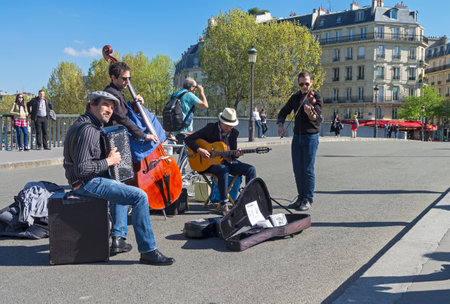 PARIS, FRANCE - APRIL 2, 2017:  Street musicians in retro style on a Saint-Louis bridge, Paris, France. A sunny day in early April.のeditorial素材