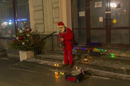 MOSCOW, RUSSIA, DECEMBER 25, 2016: A street musician dressed as Santa Claus plays the saxophone. Moscow, Russia, December 2106.のeditorial素材