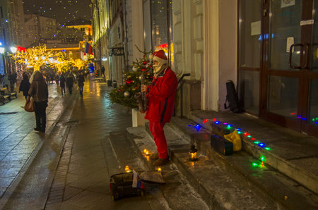 MOSCOW, RUSSIA, DECEMBER 25, 2016: A street musician dressed as Santa Claus plays the saxophone. Kuznetsky Most street, Moscow, Russia, December 2106.のeditorial素材