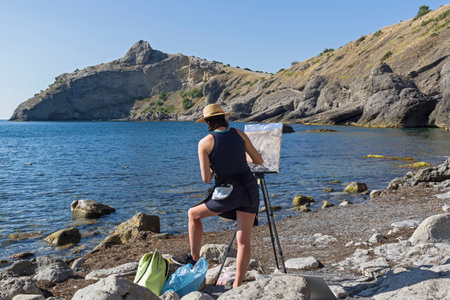 NOVYY SVET, CRIMEA - SEPTEMBER 2, 2017: The artist in the open-air. Sunny summer morning. Little bay in the Crimea.のeditorial素材