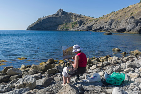NOVYY SVET, CRIMEA - SEPTEMBER 2, 2017: The artist in the open-air. Sunny summer morning. Little bay in the Crimea.のeditorial素材