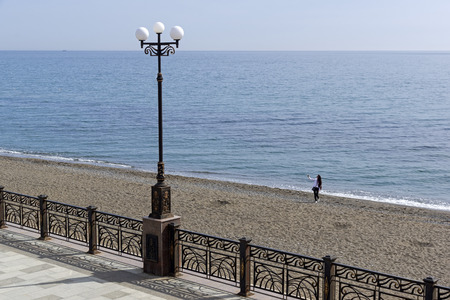 Off-season. A lonely girl makes selfie on an empty beach. Crimea, spring, early April.の写真素材
