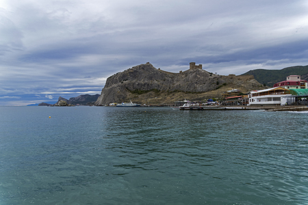 View of the coastal mountain with a medieval Genoese fortress across the bay. Sudak, Crimea, cloudy day in September.の写真素材