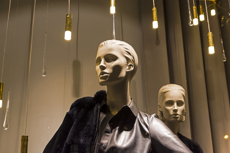 Showcase of an expensive clothing store. Mannequins in fashionable and expensive clothes.