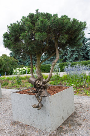 Moscow, Russia - July 6, 2018: Bronze figure of a leprechaun at the root of a tree - Garden sculpture at Moscow Flower Show.のeditorial素材