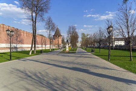 A small park between the wall of the Tula Kremlin and Mendeleevskaya street. View of the monument to Karl Marx and the Nikitsky Tower. Sunny day at the end of April. Tula, Russia.の写真素材