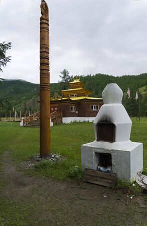 Buddhist datsan. A wooden pillar with a horse head at the top and a street hearth on a wooden pangoda background.The village of Orlik, Buryatia, Russia.の写真素材