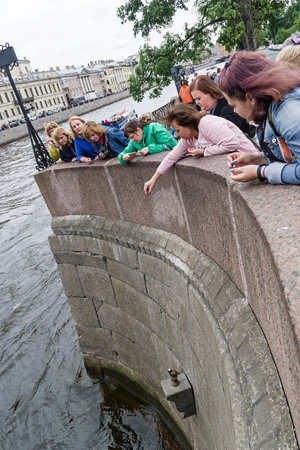 Saint Petersburg, Russia - June 14, 2019:Tourists throw coins for good luck at the  statue of Chizhik-Pyzhik. Fontanka River Embankment at the 1st Engineering Bridge.のeditorial素材
