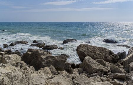 Strong surf on the rocky seashore. Crimea, a sunny day in September.