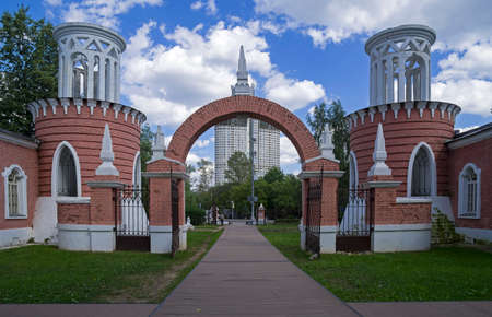 Entrance gates in the park of the estate of Vorontsovo against the background of a modern building. Moscow, Russia, sunny day in July.の写真素材