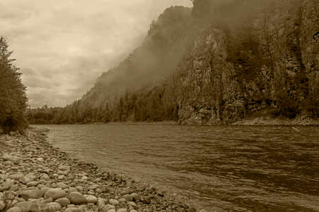 Low clouds over the river. Rocks on the banks of the Oka Sayanskaya River, Irkutsk region, Siberia,...